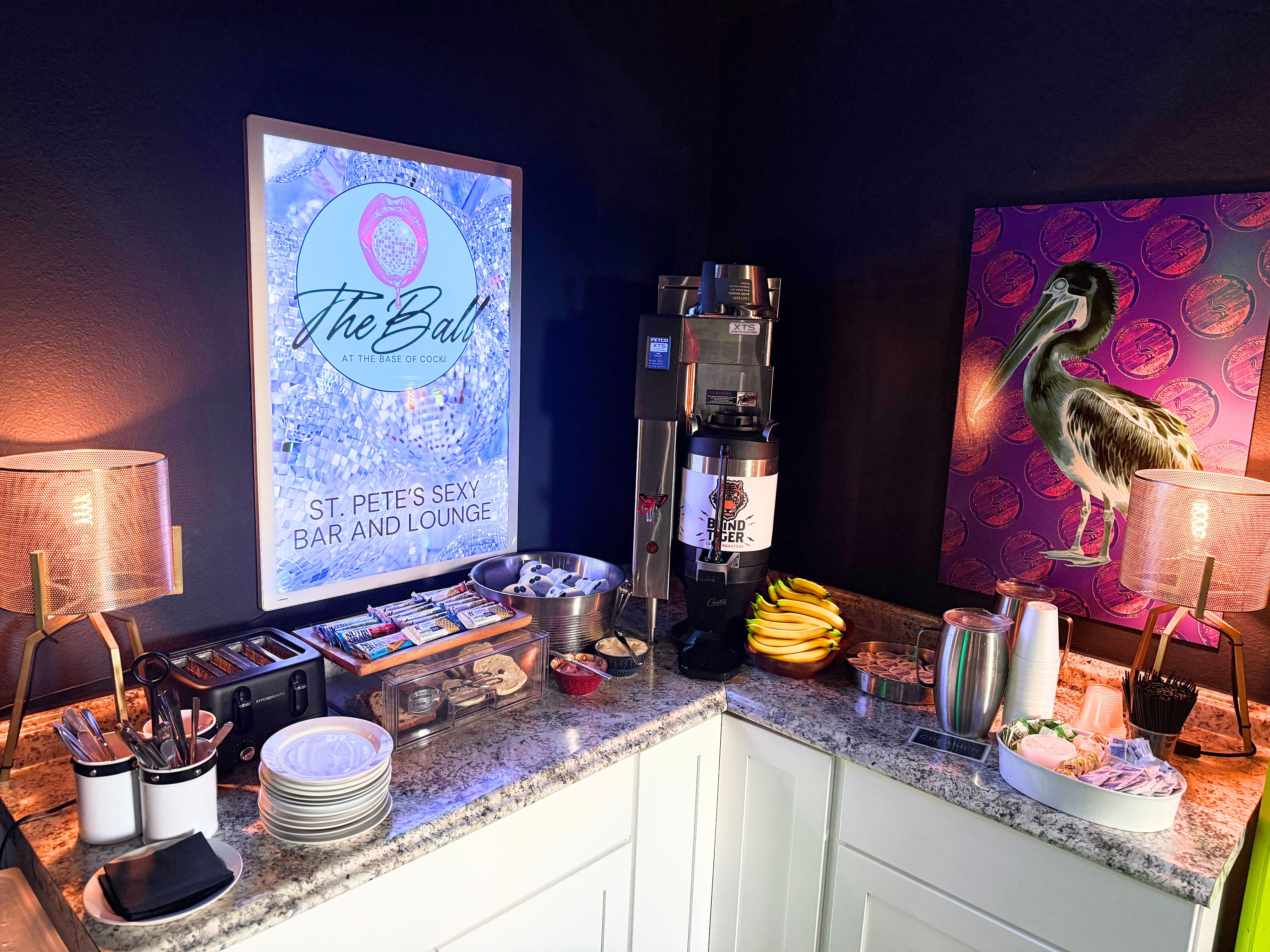 A bar area with a digital screen displaying "The Ball" and a coffee machine.