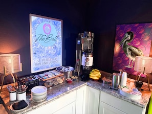 A bar area with a digital screen displaying "The Ball" and a coffee machine.