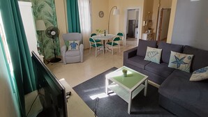 A living room with a sofa, a coffee table, a TV, and a dining area with chairs and a table. - Atlantic Terrace. An oasis in the city. (Santa Cruz de Tenerife)