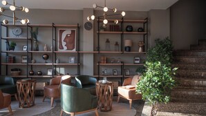 Un interno moderno con un'area salotto, mensole in legno con diversi oggetti e una scala.