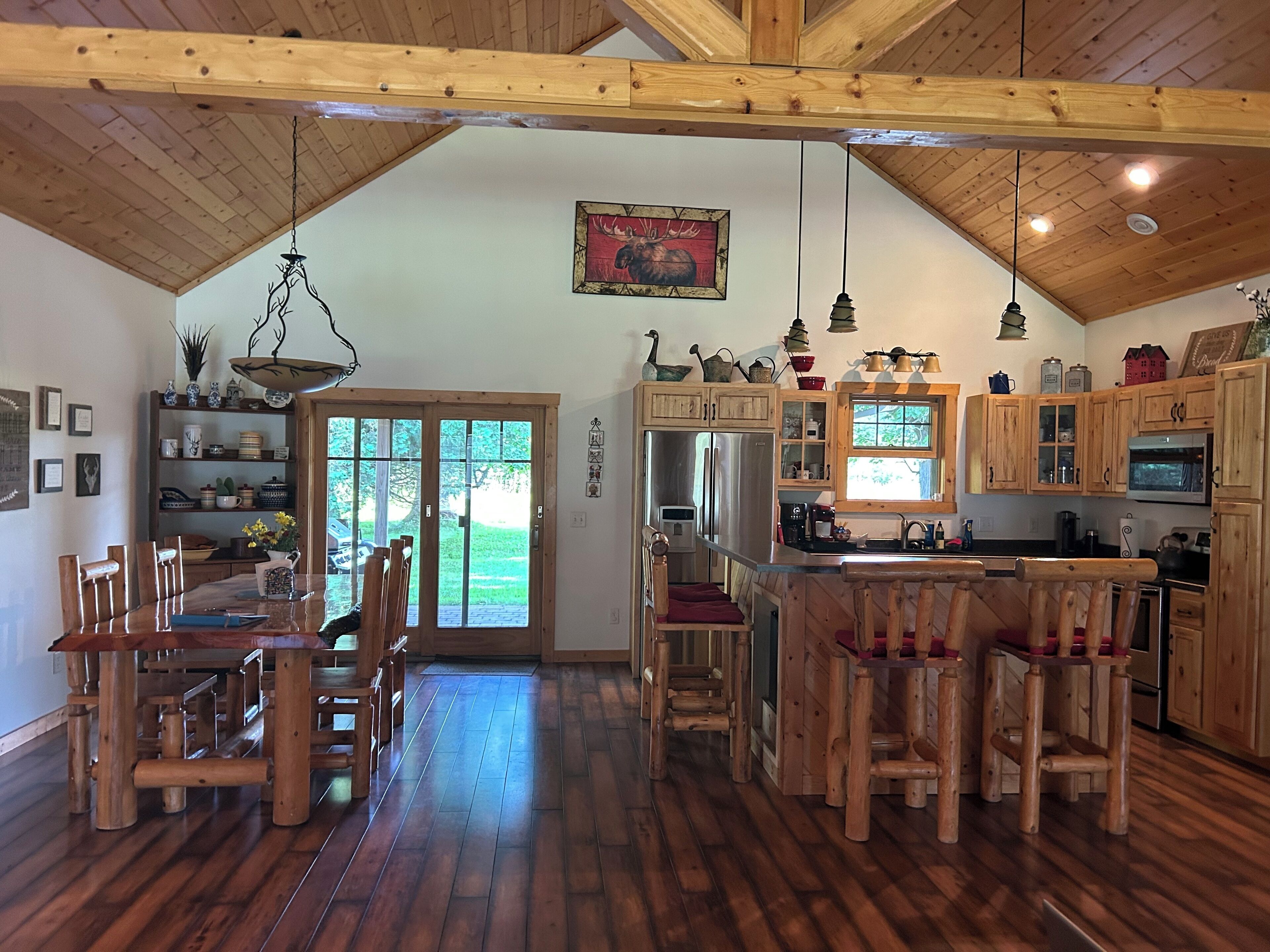 A spacious kitchen with wooden cabinets, a central island, and a dining area with wooden chairs.
