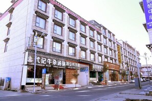 A multi-story building with commercial establishments on the ground floor. - Daozhimeng Hotel (Daocheng County)