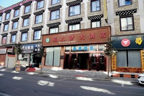 A hotel with a traditional facade, multiple windows, and a prominent entrance. - Daozhimeng Hotel (Daocheng County)