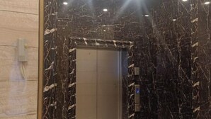 An elevator with a marble wall and a digital display. - Daozhimeng Hotel (Daocheng County)