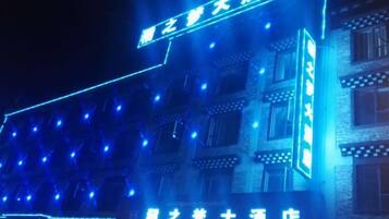 A building with illuminated signage and multiple windows.