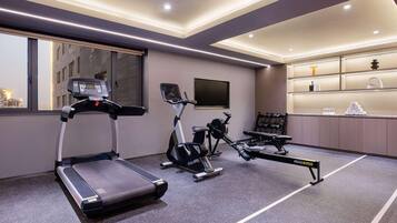 A modern gym with treadmills, stationary bikes, and a rowing machine.