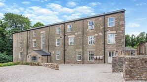 A large stone building with multiple windows and a gravel driveway. - 2 bedroom accommodation in Casterton, near Kirkby Lonsdale (Casterton, near Kirkby Lonsdale)
