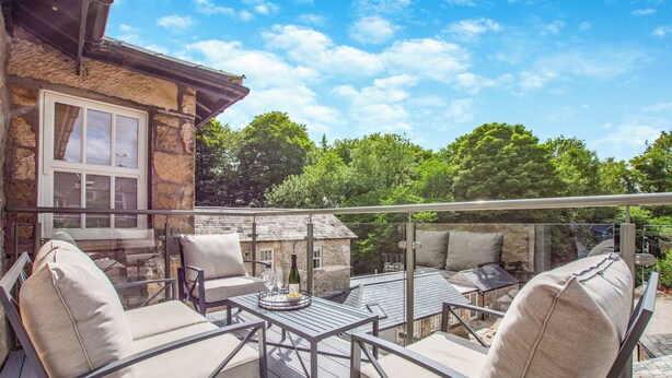 A patio with outdoor furniture, a table with a bottle and glasses, and a stone building in the background. - 2 bedroom accommodation in Casterton, near Kirkby Lonsdale (Casterton, near Kirkby Lonsdale)