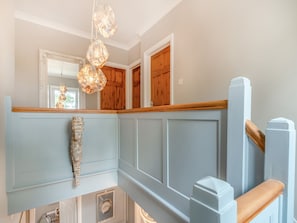 Une pièce avec un banc en bois, un mur décoratif en pierre et un luminaire suspendu.