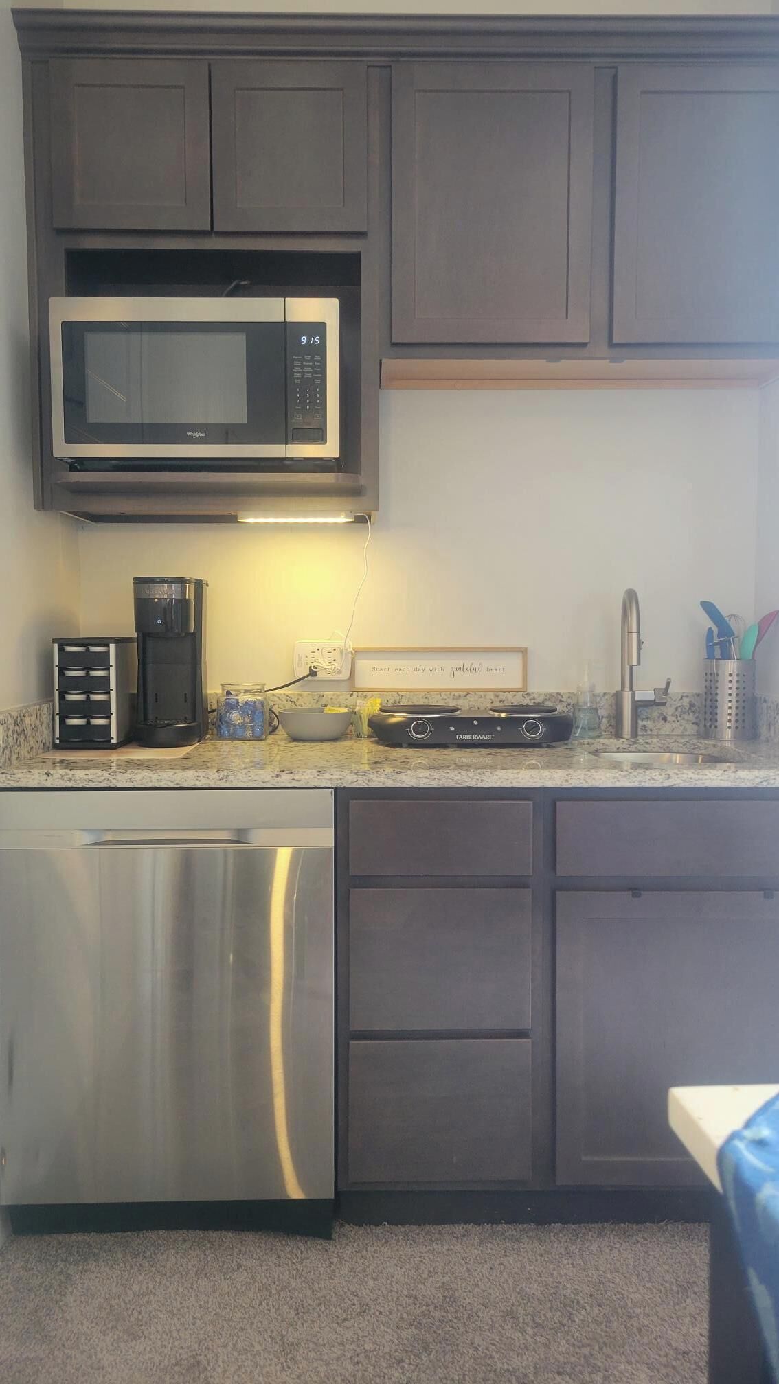A kitchen with a built-in microwave, coffee maker, and a toaster.