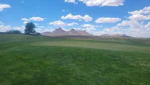 Un campo de golf con una vista despejada de montañas al fondo.