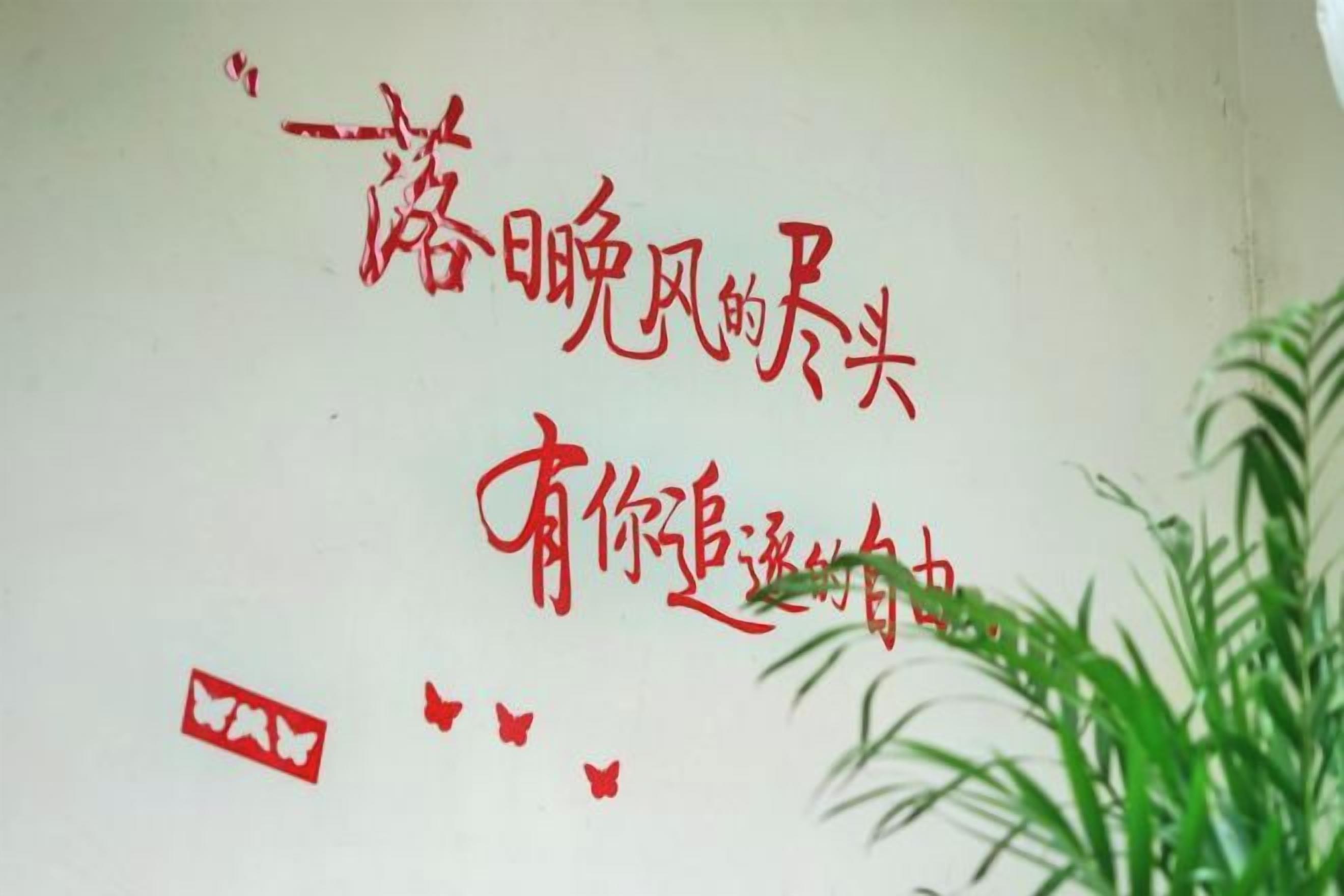 Parede com caracteres chineses vermelhos e um símbolo quadrado vermelho.