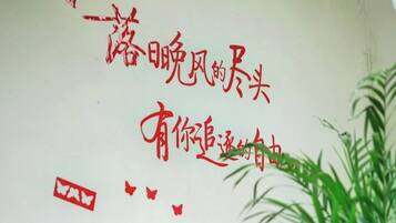 Parede com caracteres chineses vermelhos e um símbolo quadrado vermelho.
