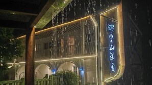 A traditional building with a sign, wooden balconies, and a covered walkway.