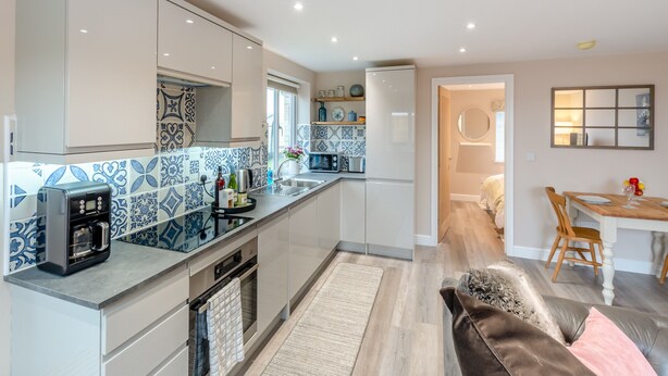 A modern kitchen with a central island, built-in appliances, and patterned backsplash tiles. - Oswald’s Rest is in an absolutely charming location and is perfect for couples. (Bamburgh, near Seahouses)