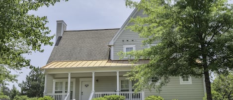 A two-story house with a front porch, a chimney, and a mailbox.