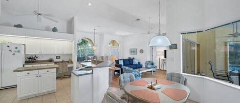 A spacious living area with a kitchen, dining table, and seating.