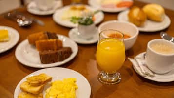 A breakfast buffet with various dishes including toast, scrambled eggs, and orange juice.