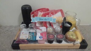 A tray with various food items and drinks, including a bottle of milk, a carton of eggs, a glass of juice, and a banana. - Hotel 1001 Prime (Ceilandia)