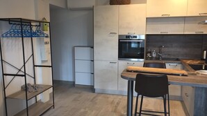 Una cocina moderna con una isla central, un tendedero y un horno empotrado.