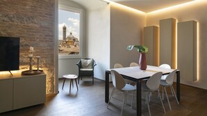 A modern dining area with a table, chairs, and a potted plant. - PALAZZO RINUCCINI - TORRE apartment (Siena)