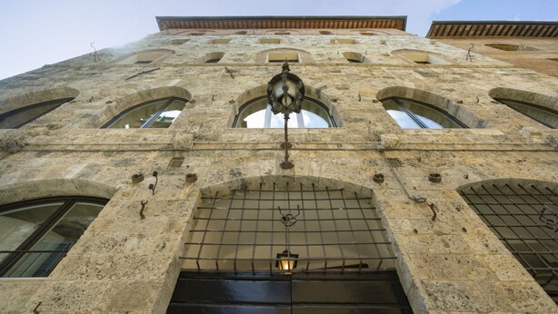 A stone building with arched windows and a central entrance. - PALAZZO RINUCCINI - TORRE apartment (Siena)
