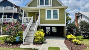 A two-story house with a front porch, a staircase, and a well-maintained garden.