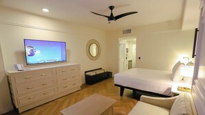 A hotel room with a bed, a television, a dresser, a mirror, and a ceiling fan. - Orlando | Compact Disney Retreat | Pool + Spa (Lake Buena Vista)