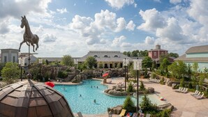 Un resort con una gran piscina, una estatua de un caballo y varios edificios.