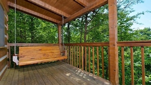 A wooden deck with a bench and a hanging swing. - Paradise #3111 (Gatlinburg)