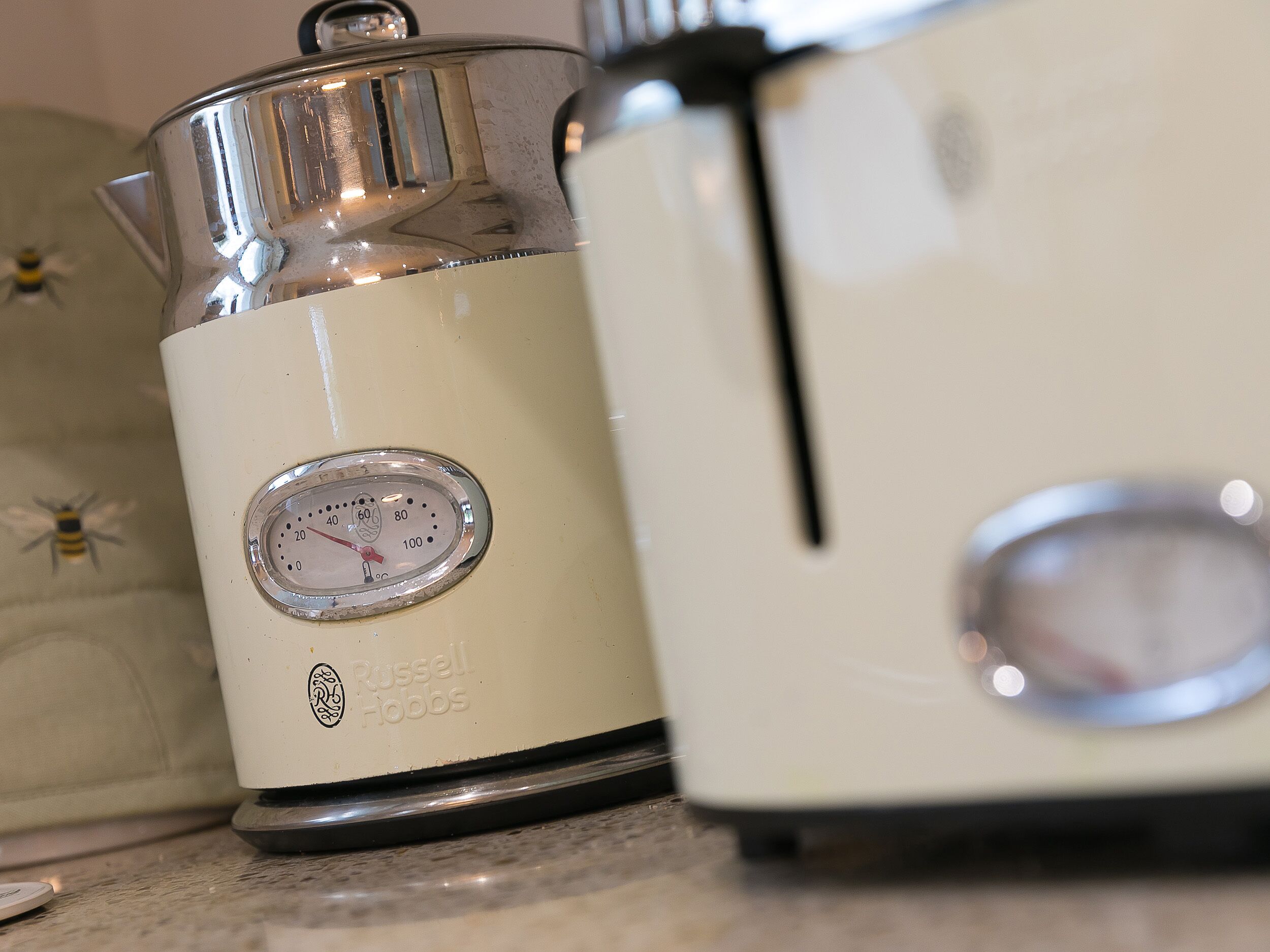 Une cuisine avec un appareil électroménager blanc, une balance et une décoration représentant une abeille.