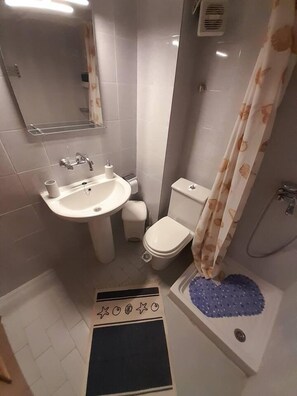 Un bany compacte amb rentapans, vàter i plat de dutxa.