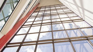 Un edificio alto con vistas al cielo a través de grandes ventanales.