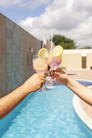 Two people toasting with drinks by a swimming pool. - Nobile Hotel Araripina (Araripina)