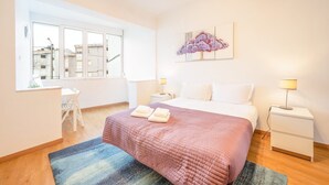 Ein Schlafzimmer mit einem Bett, zwei Nachttischen, einem Schreibtisch und einem Stuhl.