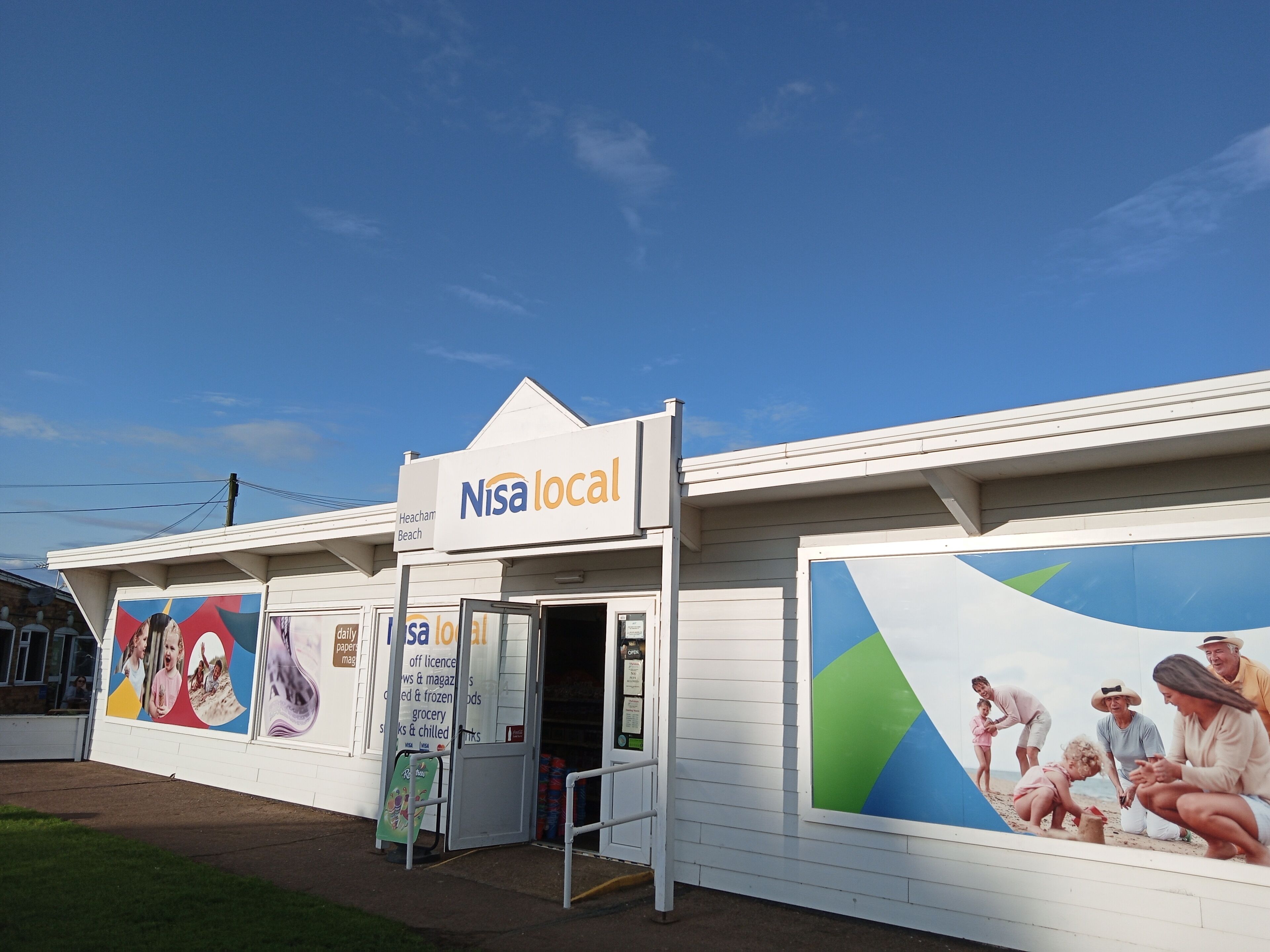 Uma loja Nisa na região, com entrada acessível, um grande anúncio exterior e uma placa indicando que se encontra em Heacham Beach.