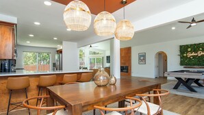 A spacious kitchen with a large island, wooden chairs, and pendant lighting. - Doodlebug de Sedona • Amenity galore (Sedona)