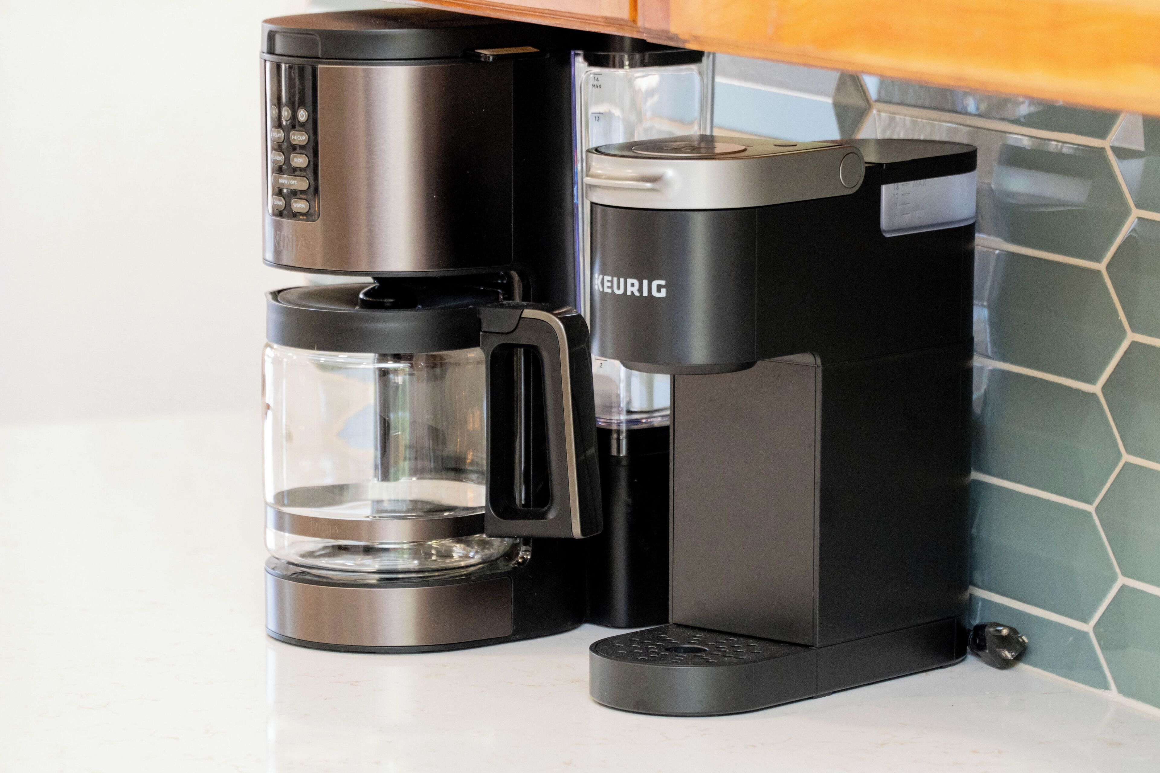 Een zwarte Keurig koffiezetapparaat met een glazen kan en een filterhouder.