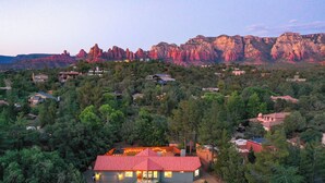 A house with a red roof surrounded by trees and a mountainous backdrop. - Doodlebug de Sedona • Amenity galore (Sedona)