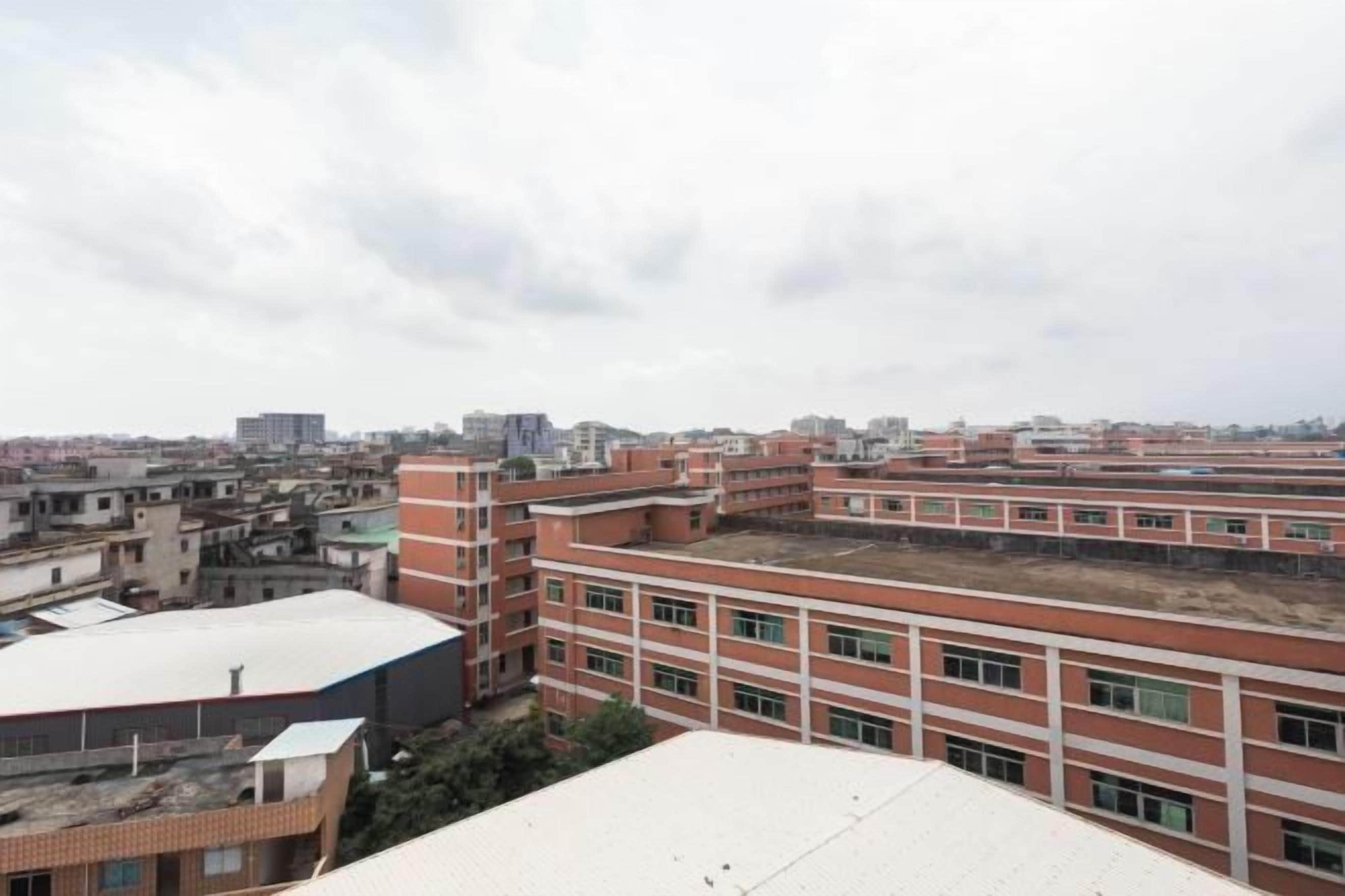 A multi-story building with a flat roof, surrounded by other buildings.