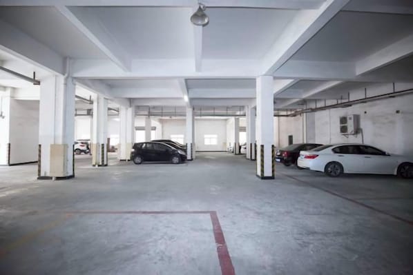 A multi-level parking garage with several cars parked. - Dongqi Business Hotel (Dongguan)