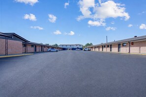 A row of single-story motel buildings with a clear sky and a few clouds.