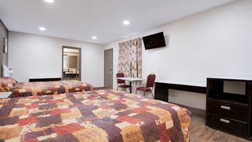 A hotel room with two beds, a desk, a chair, a television, and a mirror.