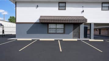 A two-story building with a flat roof, a covered entrance, and a parking lot in front.