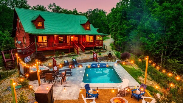 A wooden cabin with a swimming pool, deck chairs, and a fire pit. - Private*Pool*HotTub*Sauna*FirePit*Theater+GameRoom (Sevierville)