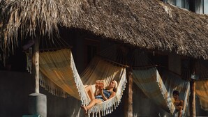 Un área de piscina con estructuras de techo de paja y hamacas.