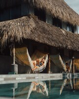 Un área de piscina con estructuras de techo de paja y hamacas.