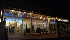 Restaurante com mesas ao ar livre, luzes de corda e um terraço coberto.