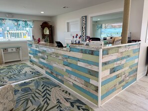 A reception desk with a nautical theme, a clock, and a view of the outside. - The VIP Family Motel (Wildwood Crest)