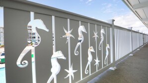 A railing with white decorative elements, including seahorses and stars, along a waterfront promenade. - The VIP Family Motel (Wildwood Crest)